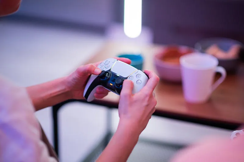 Hands holding a PlayStation DualSense controller, an example of multi-actuator haptics
