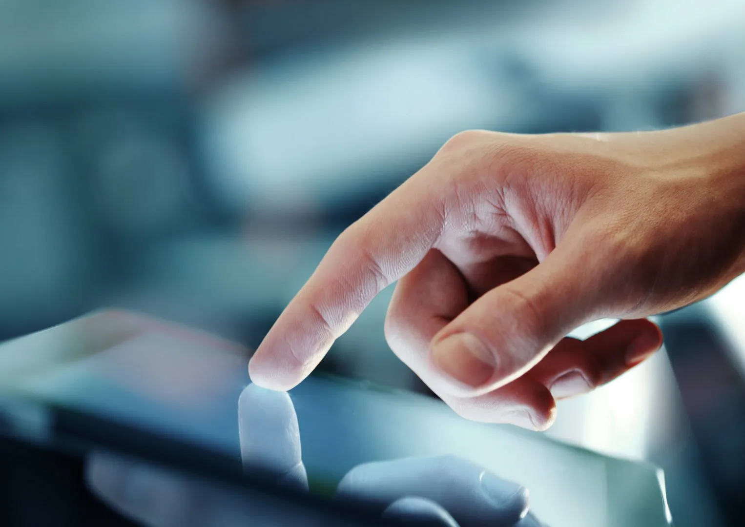Finger touching a tablet screen, illustrating haptics use case objectives