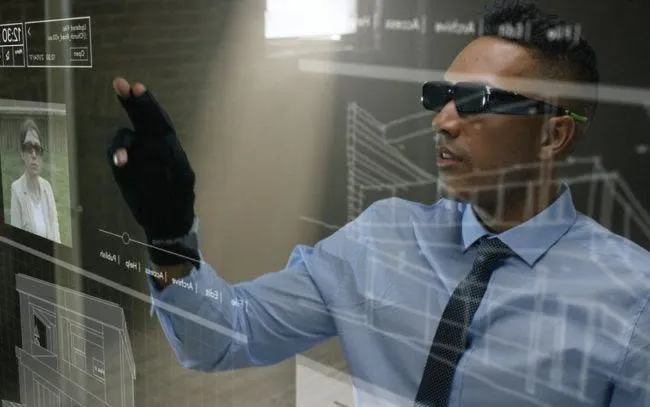 Man wearing a glove gesturing at a holographic interface, illustrating gesture-based hand interaction
