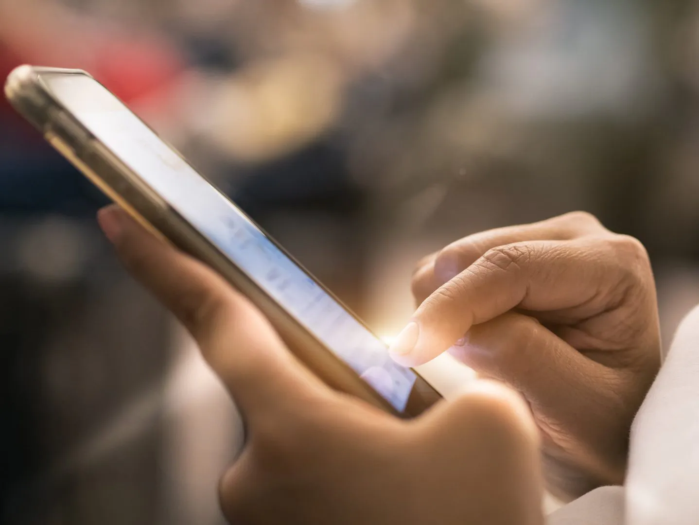 Hands touching a smartphone screen, illustrating haptic rendering in online shopping